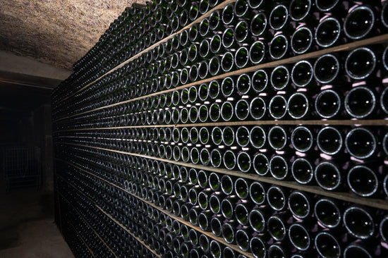 Rows of champagne grand cru bottles  Yvonne Belhomme stacked in a dark storage room